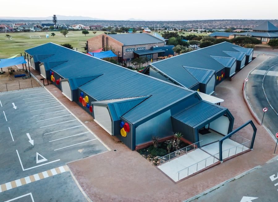 Aerial view of the centre's pitched blue roofs, parking area and covered walkway.